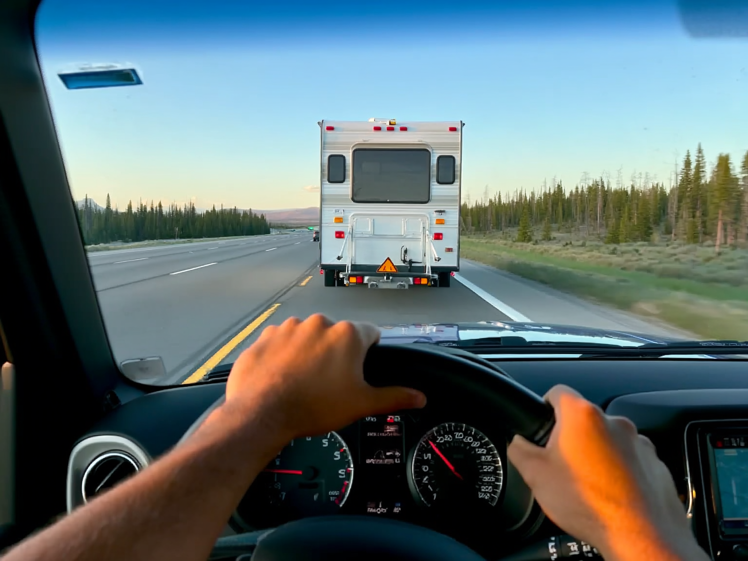 Close view of driver hands controlling a tow vehicle on a Wyoming road