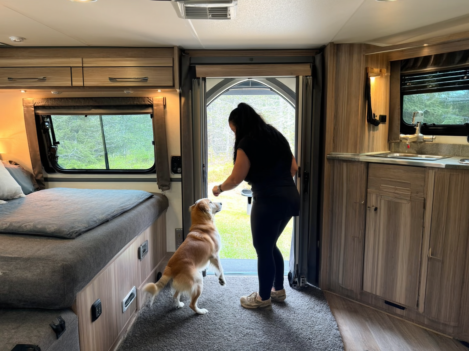 Pet owner wiping dog paws at an RV doorway before stepping onto carpet