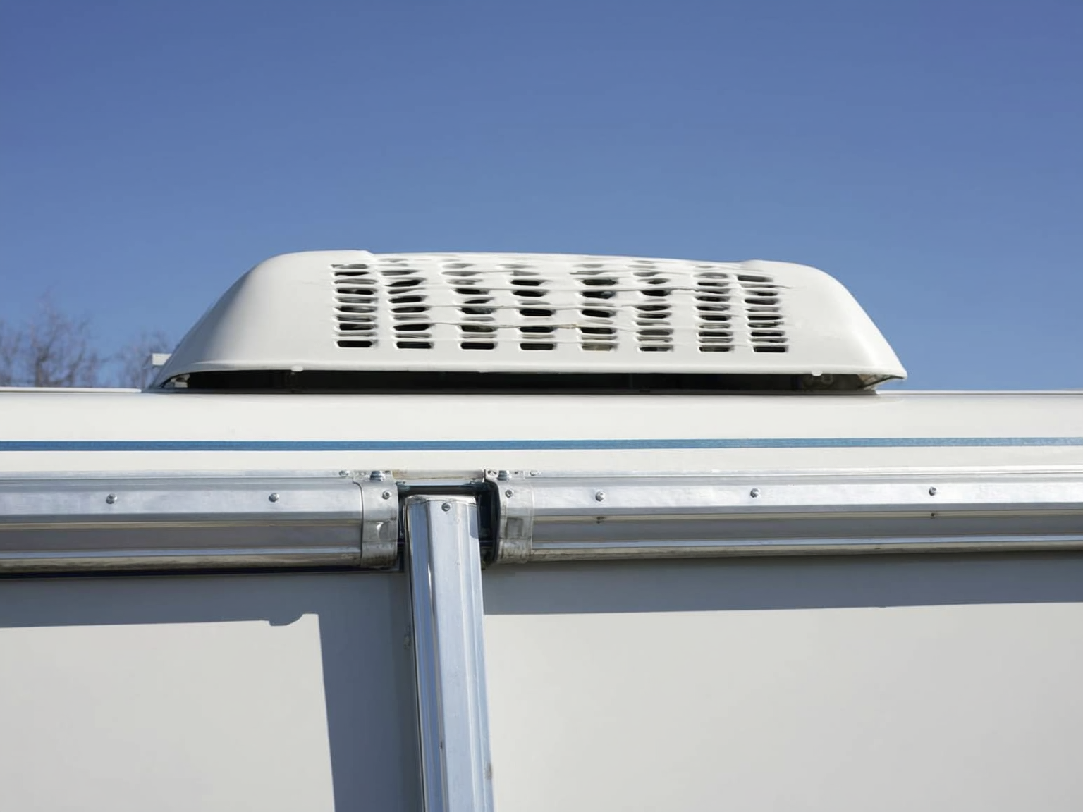 Close-up of RV roof seam and front cap inspection for water damage prevention