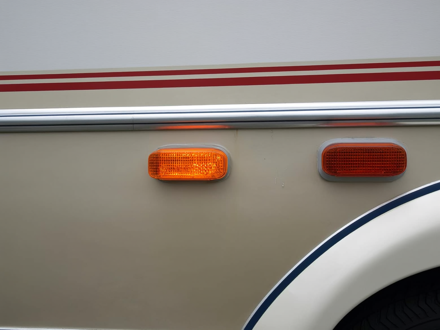 Close view of RV marker lights and exterior seam being checked for leak risk