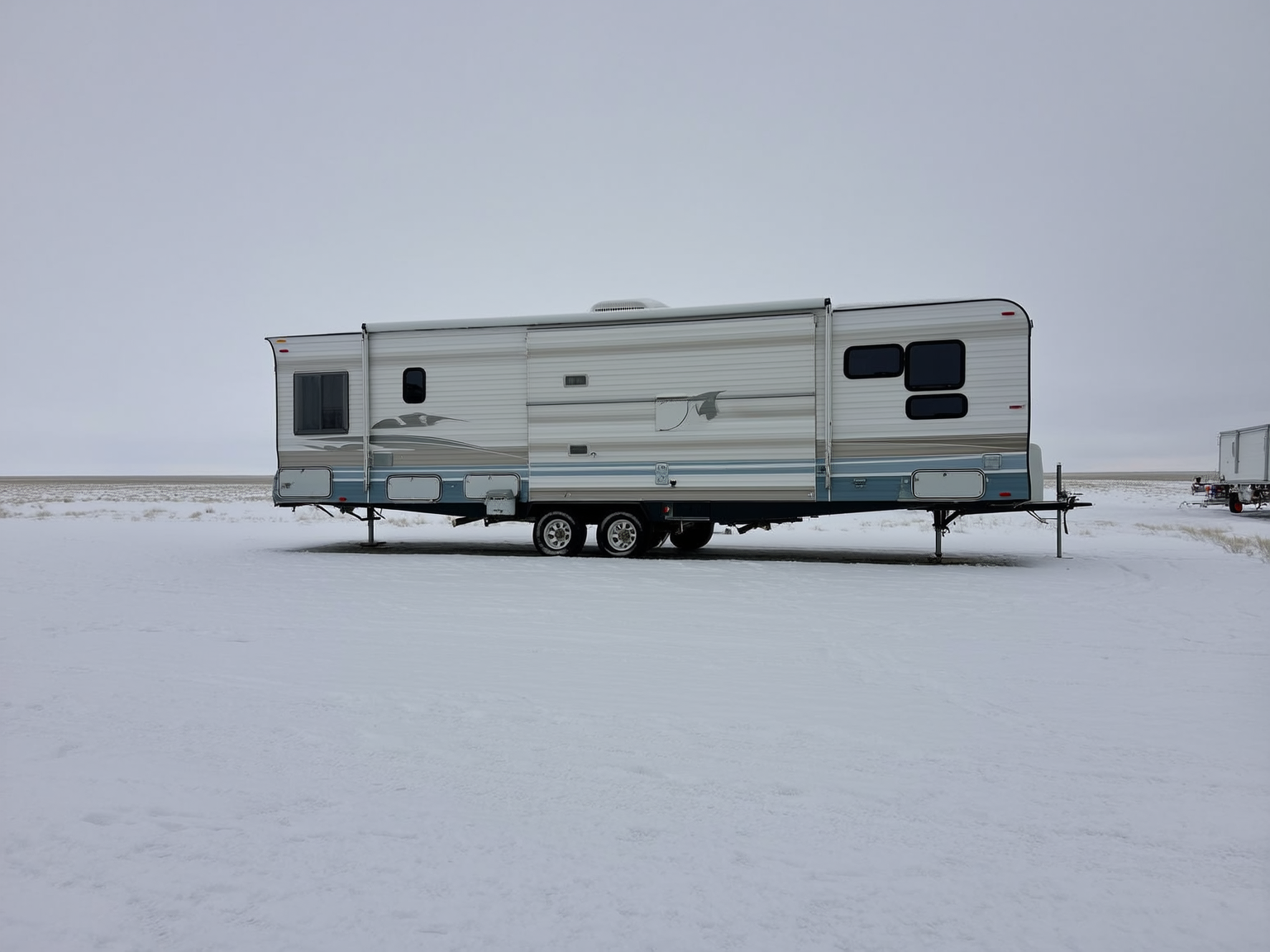 Travel trailer set up for winter at a snowy full-hookup Casper RV site